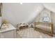 Bright bedroom features sloped ceiling, carpet, and a wooden crib with plenty of natural light at 1623 Hoyt Ave, Indianapolis, IN 46203