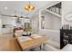 Open concept dining room with modern chandelier, wood table, and view of the kitchen with stainless steel appliances at 1623 Hoyt Ave, Indianapolis, IN 46203