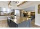 Kitchen island with sink and view of the dining area and fireplace beyond a half wall at 17320 Joliet Rd, Westfield, IN 46074