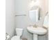 Modern powder room boasts a pedestal sink, decorative mirror, and updated fixtures for a convenient space at 1758 Pelham Dr, Greenwood, IN 46143