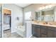 Bathroom boasts dual sinks, modern fixtures, wood-look flooring, and a soaking tub near the glass-door shower at 1758 Pelham Dr, Greenwood, IN 46143
