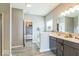 Elegant bathroom boasts dual sinks, modern fixtures, wood-look flooring, and a soaking tub near the walk-in closet at 1758 Pelham Dr, Greenwood, IN 46143