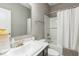Simple, bright bathroom offers a tub and shower combination behind a shower curtain, and a gray vanity sink at 1758 Pelham Dr, Greenwood, IN 46143