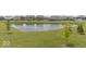Community pond with lush green surroundings and views of neighborhood houses at 1758 Pelham Dr, Greenwood, IN 46143