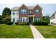Charming two-story brick home featuring a well-manicured lawn and inviting walkway at 17877 Kinder Oak Dr, Noblesville, IN 46062