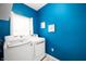 Laundry room features front load washer and dryer and bright blue walls at 17877 Kinder Oak Dr, Noblesville, IN 46062