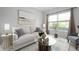 Bright living room featuring a comfortable white sofa, stylish decor, and ample natural light from a large window at 17877 Kinder Oak Dr, Noblesville, IN 46062