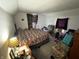 Bedroom features a queen bed, patterned drapes, and cozy armchair bathed in natural light at 1809 E 13Th St, Muncie, IN 47302