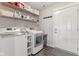 Well-organized laundry room featuring a washer, dryer, shelving, and a convenient doorway to the outside at 19387 Astoria Ave, Sheridan, IN 46069