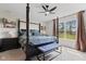 A spacious main bedroom with a four-poster bed, a ceiling fan, and a bright window at 19387 Astoria Ave, Sheridan, IN 46069