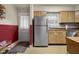 Kitchen area with stainless steel refrigerator and wood cabinets, with red accent wall at 1944 Union St, Columbus, IN 47201