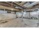View of the unfinished basement with concrete floor and exposed ceiling beams, water heater in view at 2245 N Ritter Ave, Indianapolis, IN 46218