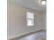 Bright bedroom with a large window and light-colored walls and grey vinyl plank floors at 2245 N Ritter Ave, Indianapolis, IN 46218