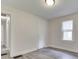 Bedroom with light-colored walls and vinyl plank flooring adjacent to hallway and door at 2245 N Ritter Ave, Indianapolis, IN 46218