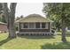 Charming home showcasing a screened-in porch with brick facade and mature trees at 2245 N Ritter Ave, Indianapolis, IN 46218