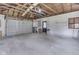 Inside of garage showing the concrete floors, unfinished ceiling, and overhead door at 2245 N Ritter Ave, Indianapolis, IN 46218