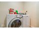 A laundry room with a white washer and dryer and laundry supplies at 2426 Autumn Rd, Indianapolis, IN 46229
