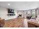 Spacious living room features a brick fireplace, modern wood flooring, and lots of natural light at 2426 Autumn Rd, Indianapolis, IN 46229