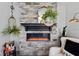 Stone fireplace with electric logs, wooden mantle and decorative accessories at 2717 Reflection Way, Greenwood, IN 46143