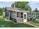 Home with a gray exterior, sunroom, and a well-maintained lawn at 2719 Denison St, Indianapolis, IN 46241
