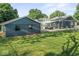 This backyard has an oversized garage with green lawn and the home has a sunroom at 2719 Denison St, Indianapolis, IN 46241