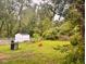 Expansive backyard featuring lush greenery, a storage shed, and a gas grill at 2954 N Drexel Ave, Indianapolis, IN 46218