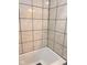 Close-up of a white bathtub with marble-like tile and black grout at 2954 N Drexel Ave, Indianapolis, IN 46218