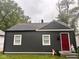View of home with dark gray siding, white trim, and a vibrant red front door at 2954 N Drexel Ave, Indianapolis, IN 46218