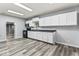 Spacious kitchen with white cabinets, black countertops and appliances, and wood-look flooring at 3529 Hunt St, Plainfield, IN 46168