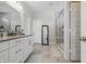 Well-lit bathroom featuring a double vanity, a large mirror, and a tiled shower area at 3839 Albert Ln, Bargersville, IN 46106