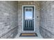 The exterior of the front door, features a welcoming welcome mat and brick surround at 3839 Albert Ln, Bargersville, IN 46106