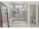 Modern walk-in shower with gray tile, a built-in bench, and glass door at 3839 Albert Ln, Bargersville, IN 46106