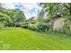 Lush backyard with manicured lawn, mature trees, and storage shed at 450 W 93Rd St, Indianapolis, IN 46260