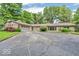 Single-story home with brick accents, a circular driveway, attached two-car garage and lush landscaping at 450 W 93Rd St, Indianapolis, IN 46260