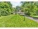 Inviting single-story home featuring an expansive green lawn, mature trees, and a private driveway at 450 W 93Rd St, Indianapolis, IN 46260