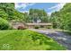 Charming home boasting a well-maintained lawn, circular driveway, and mature landscaping for added privacy at 450 W 93Rd St, Indianapolis, IN 46260