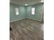 Bright living room with two windows and neutral colored walls and wood look flooring at 4715 Normal Ave, Indianapolis, IN 46226