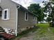 Exterior side view showing siding, white trim and a small grass and gravel area at 4715 Normal Ave, Indianapolis, IN 46226