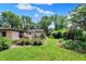 Lush backyard featuring garden beds, lawn, and mature trees on a sunny day at 4770 Willow Rd, Zionsville, IN 46077