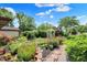 Expansive backyard featuring garden beds, lush greenery, and sunny skies at 4770 Willow Rd, Zionsville, IN 46077