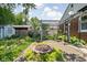 Landscaped backyard featuring a brick patio, fire pit, garden beds, and a storage shed at 5126 Hillside Ave, Indianapolis, IN 46205