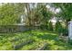 Lush backyard with garden beds, mature trees, and a wooden fence, providing a private outdoor retreat at 5126 Hillside Ave, Indianapolis, IN 46205