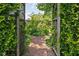 View of lush greenery through wooden gate with foliage around the path at 5126 Hillside Ave, Indianapolis, IN 46205