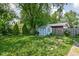 Expansive backyard featuring a storage shed, mature trees, and beautiful landscaping at 5126 Hillside Ave, Indianapolis, IN 46205