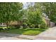 A well-manicured front yard with mature trees complements this home's charming curb appeal and brick and blue siding at 5126 Hillside Ave, Indianapolis, IN 46205