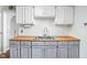 Stylish kitchen featuring butcher block counters and white backsplash with stainless steel sink at 5126 Hillside Ave, Indianapolis, IN 46205