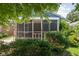 An inviting screened in porch with greenery enhancing its appeal to relax in the comfort of your home at 5126 Hillside Ave, Indianapolis, IN 46205