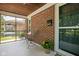 A spacious screened porch features brick accent walls, outdoor chairs, and seamless transition to front entrance of this home at 5126 Hillside Ave, Indianapolis, IN 46205
