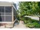 This home features a quaint side exterior with a screened-in porch, complemented by charming landscaping and a concrete walkway at 5126 Hillside Ave, Indianapolis, IN 46205