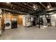 Unfinished basement with exposed ductwork, includes laundry area with modern washer and dryer, plus storage at 5261 N Pennsylvania St, Indianapolis, IN 46220